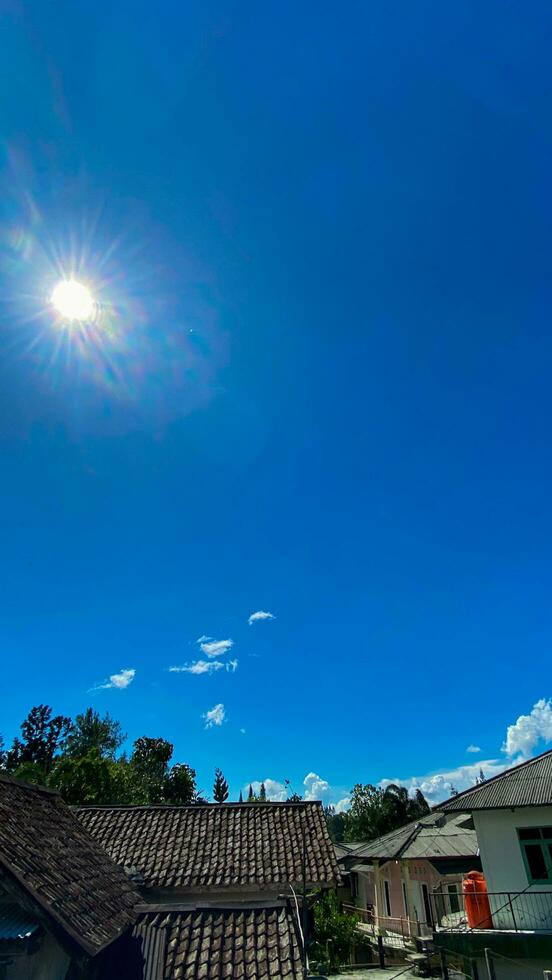 A blue sky with clouds and a sun photo