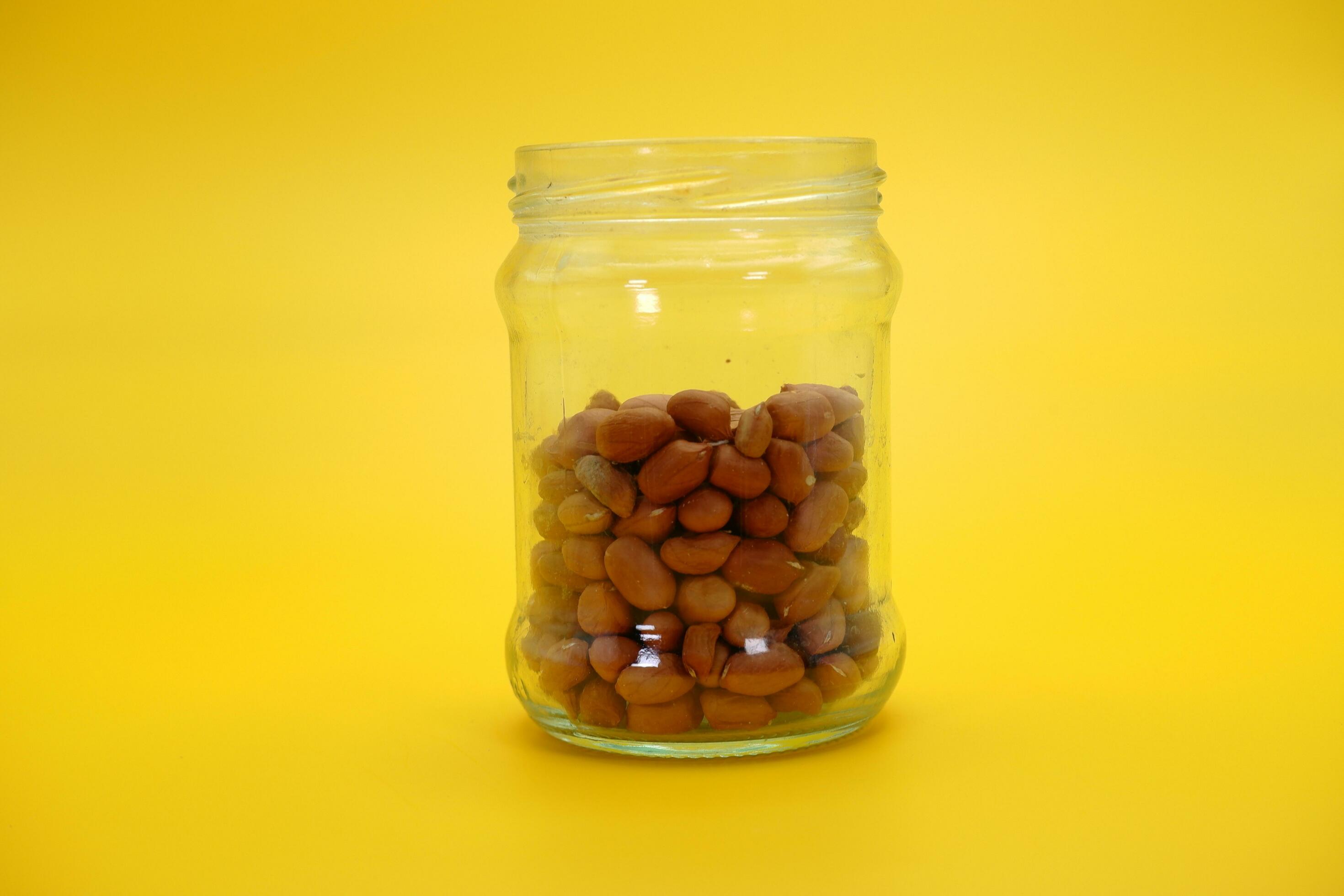 open glass jar half filled with shelled nuts 25286811 Stock Photo at