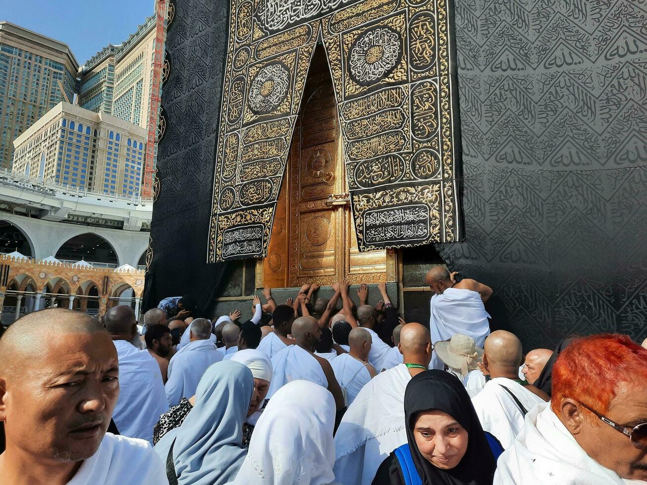 Mecca, Saudi Arabia, April 2023 - Umrah pilgrims from all over the world gather in the courtyard of Masjid al-Haram near the door of the Kaaba. photo