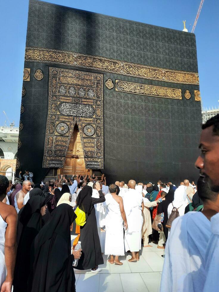 Mecca, Saudi Arabia, April 2023 - Umrah pilgrims from all over the world gather in the courtyard of Masjid al-Haram near the door of the Kaaba. photo