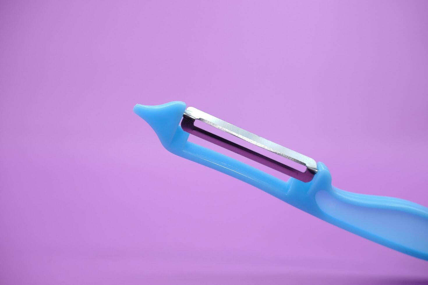 blue paring knife isolated purple background. kpas knife taken with a landscape angle. photo