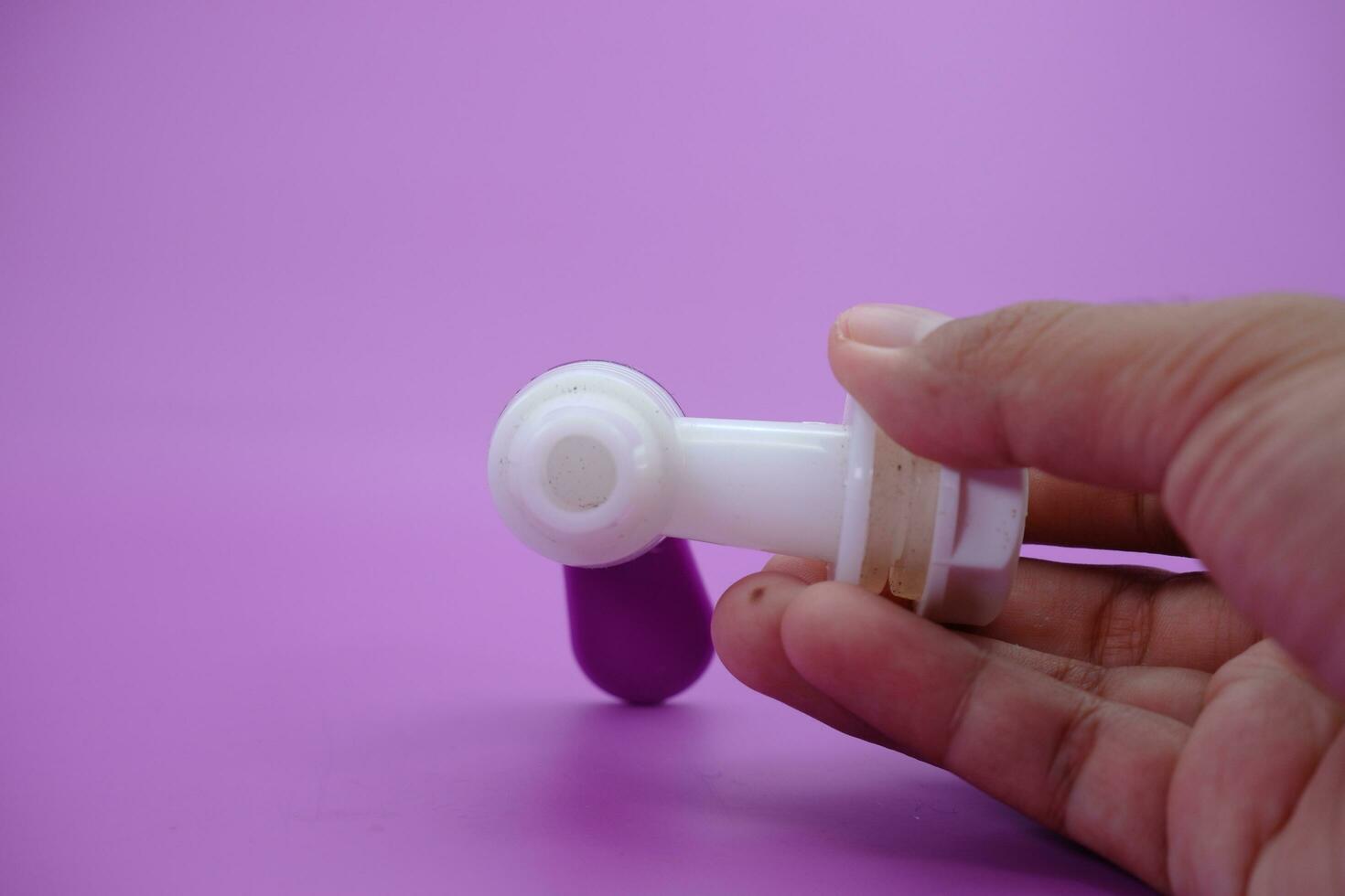 hand holding faucet isolated purple background. photo