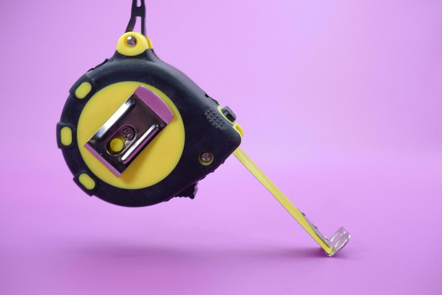 tape measure isolated purple background. measuring tool used by builders. photo
