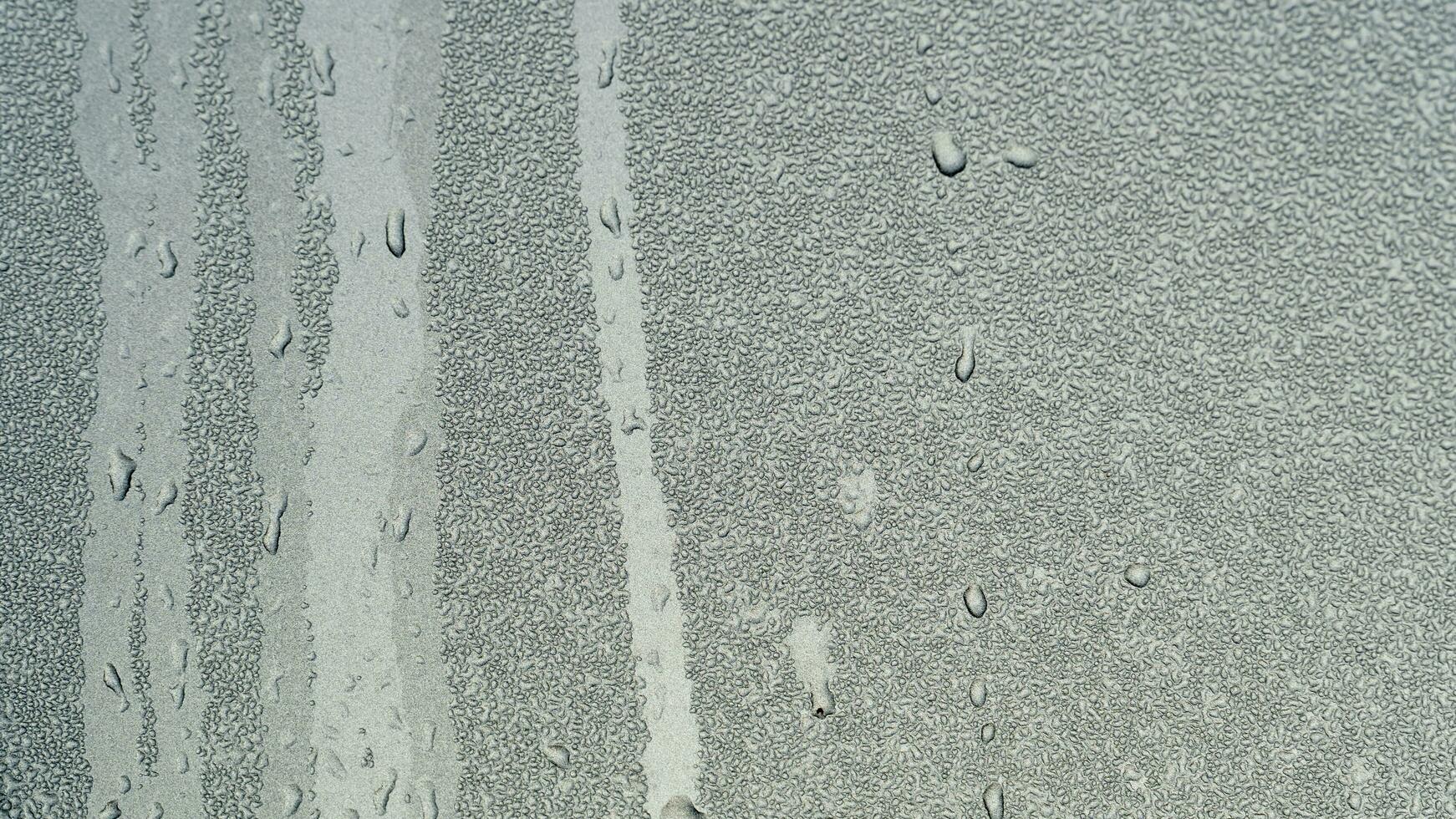 Abstract background of running path of water droplets on gray steel surface. Many fine spots of water droplets on the steel surface. photo