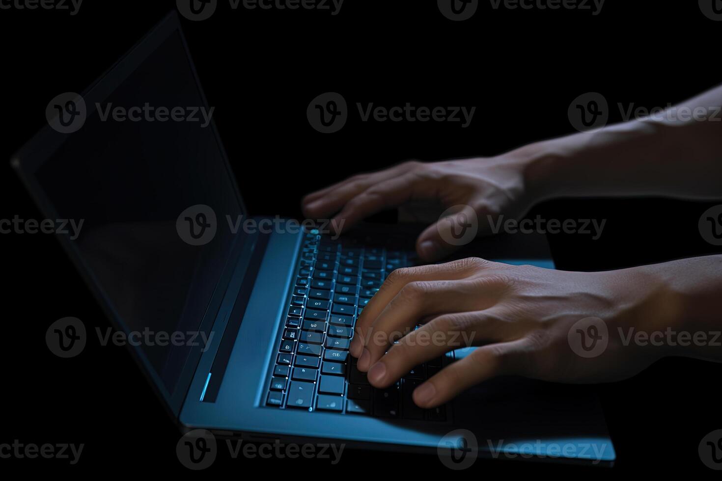 Man working on laptop computer in the dark. photo