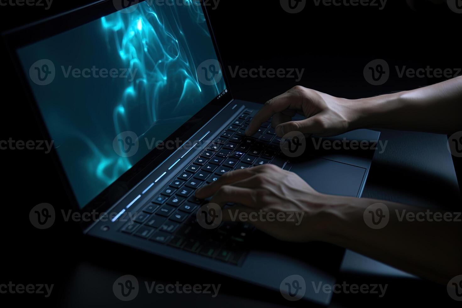 Man working on laptop computer in the dark. photo