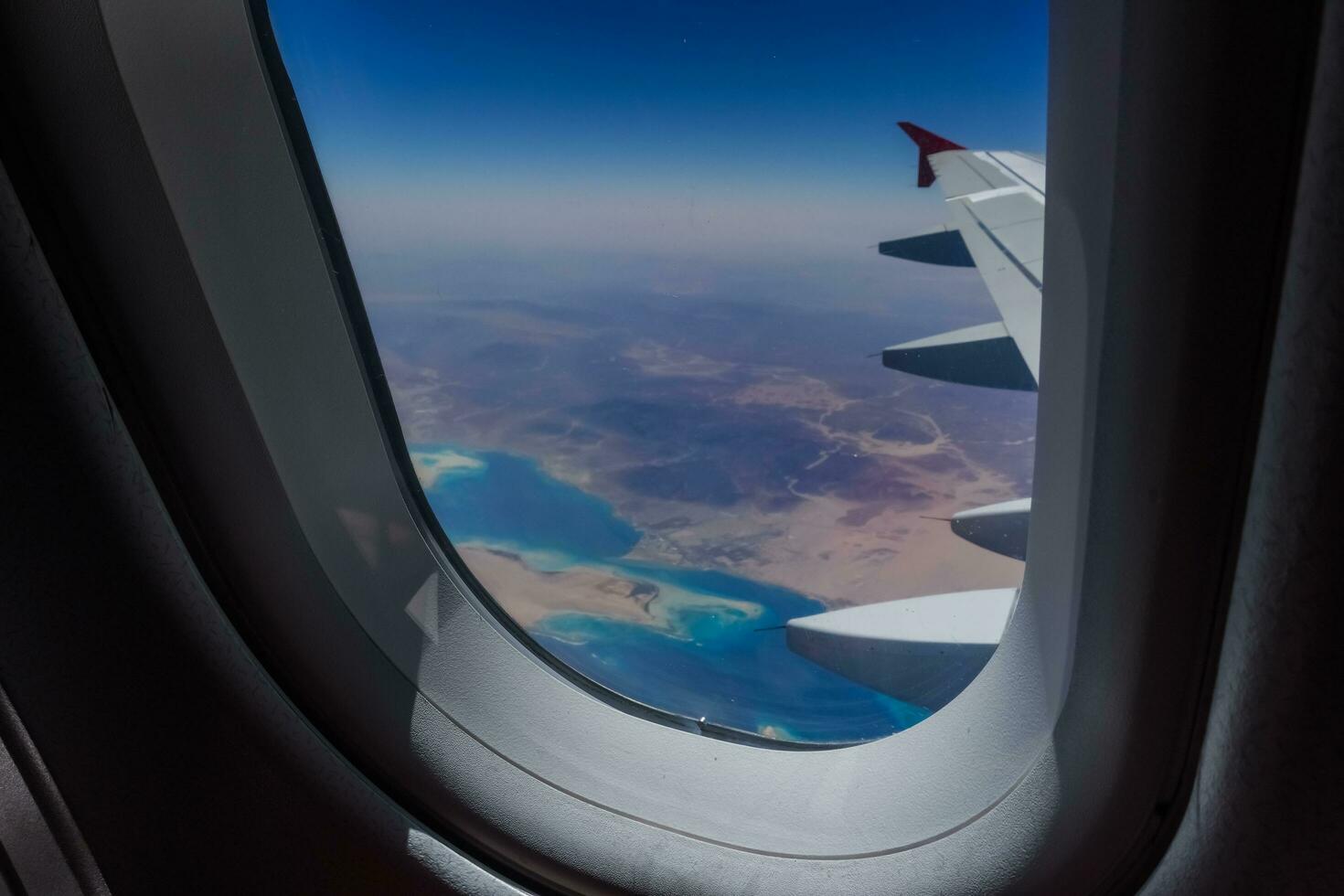 view through the window from an airplane during a flight over the desert with the red sea photo