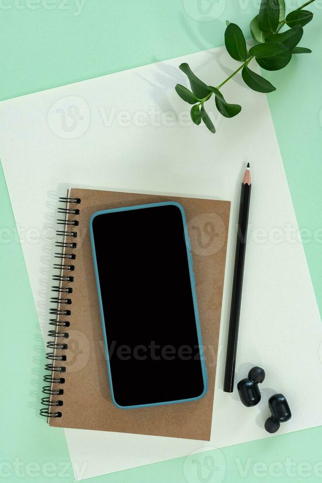 Flat lay desk workspace with empty blank paper, notebook and mobile phone. photo