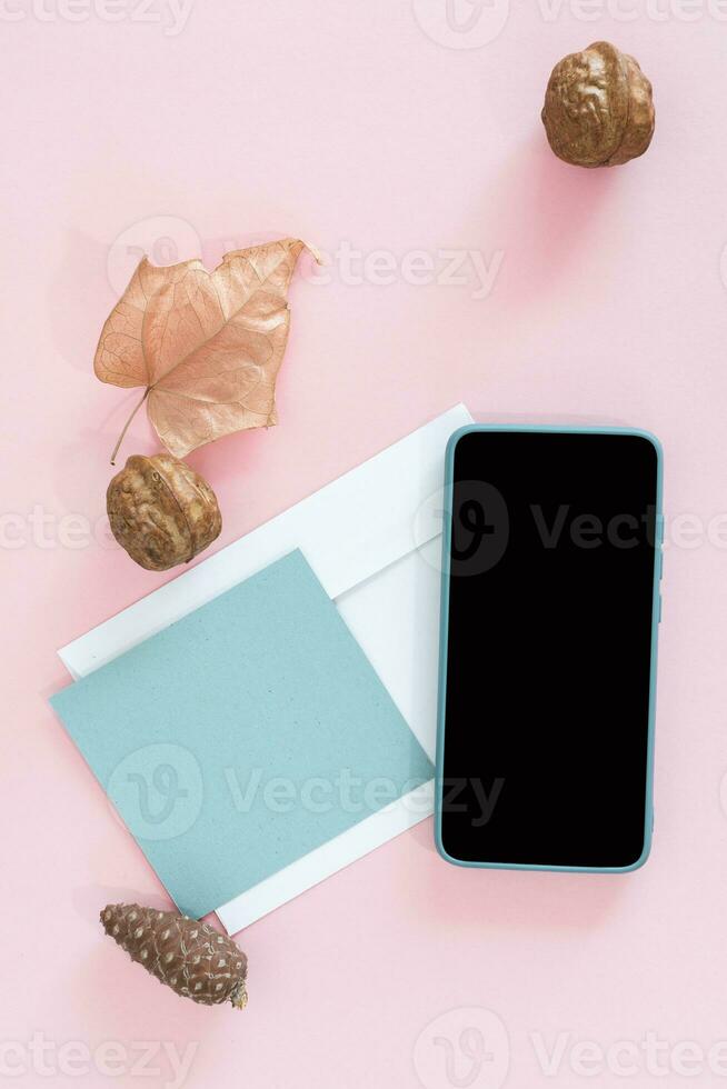 Winter or autumn concept with smart phone and greeting card on desk. photo