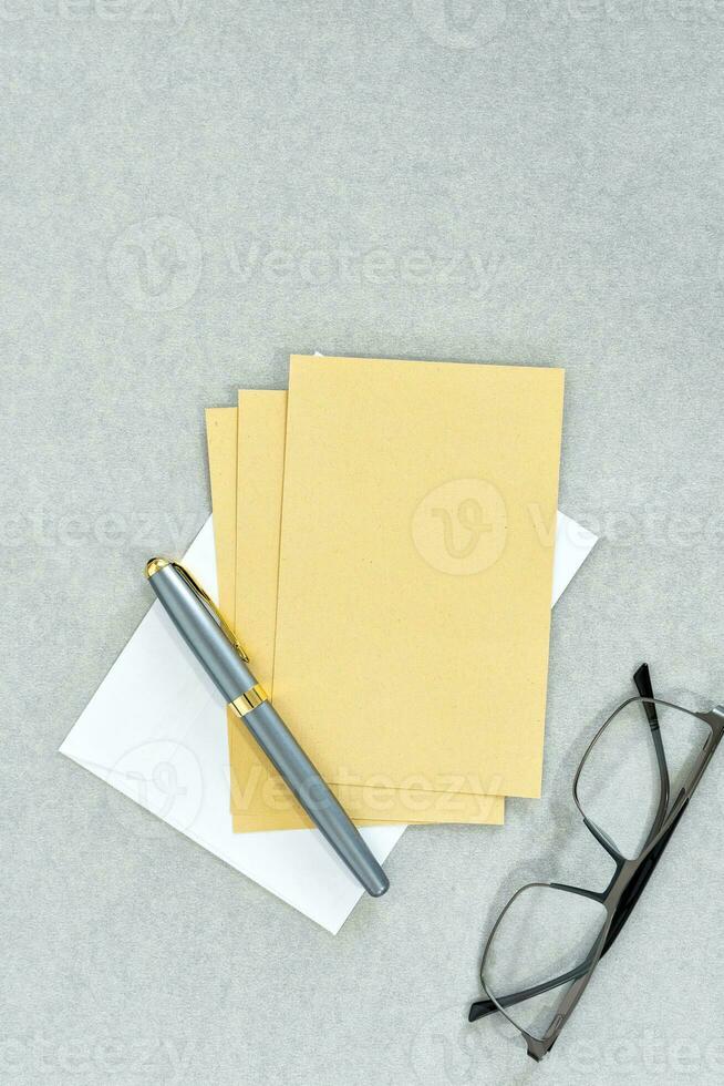 Greeting card with pen and glasses on gray background. photo