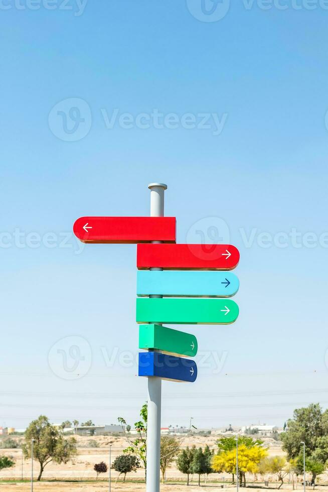 Blank signpost with many directions against blue sky in sunny day. Mockup. copy space. photo