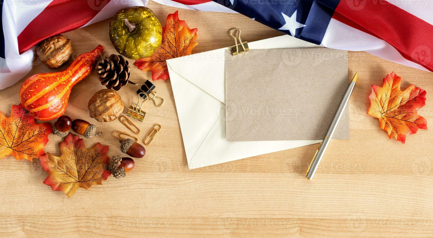 Autumn banner of flag, pumpkins, gourds and fall decor on a wood background with copy space greeting. photo