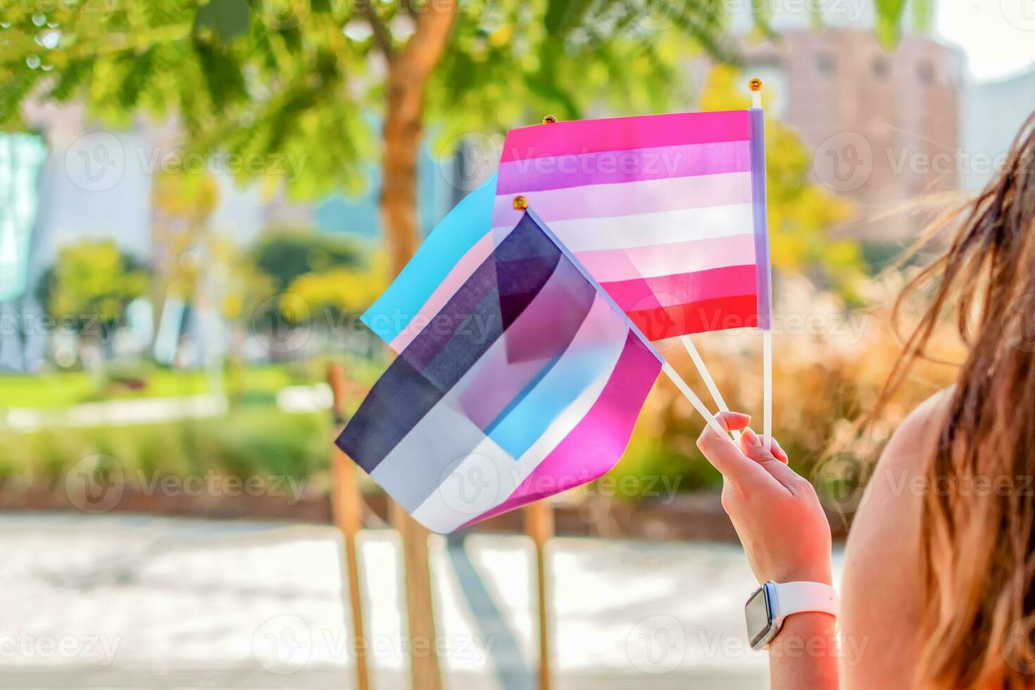 Gender queer. Woman wave LGBTQ gay pride rainbow flags at a pride event. Selective focus. photo