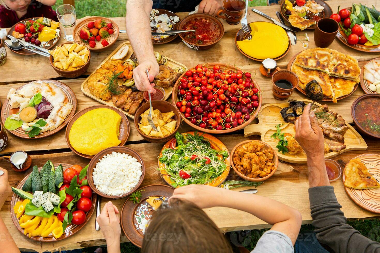 Homemade Romanian Food with grilled meat, polenta and vegetables Platter on camping. Romantic traditional moldavian food outside on the wood table. photo