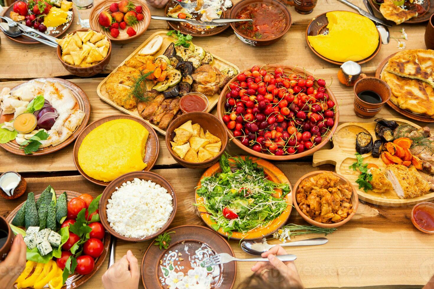 Homemade Romanian Food with grilled meat, polenta and vegetables Platter on camping. Romantic traditional moldavian food outside on the wood table. photo