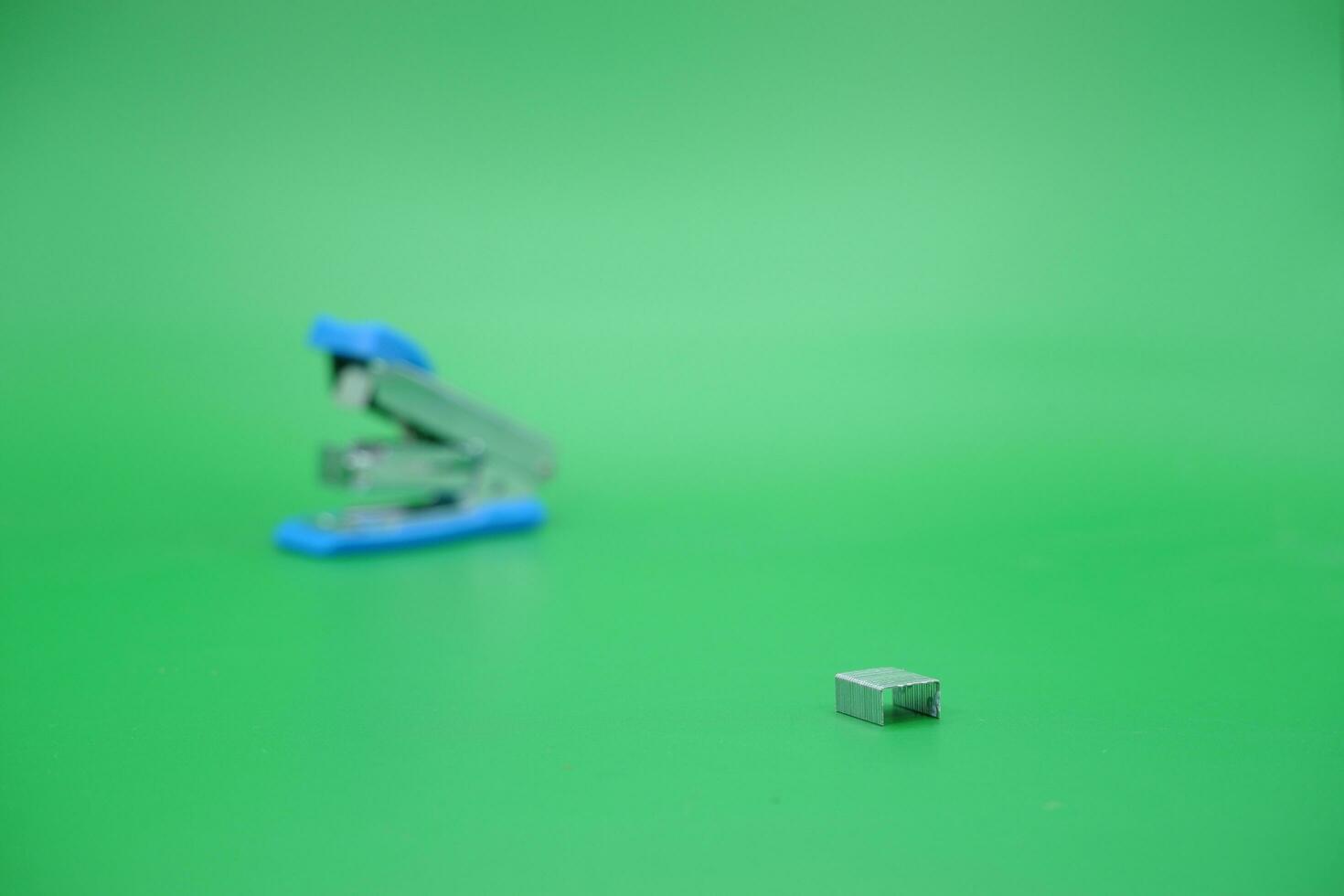 stapler refill and blurred stapler isolated green background. photo