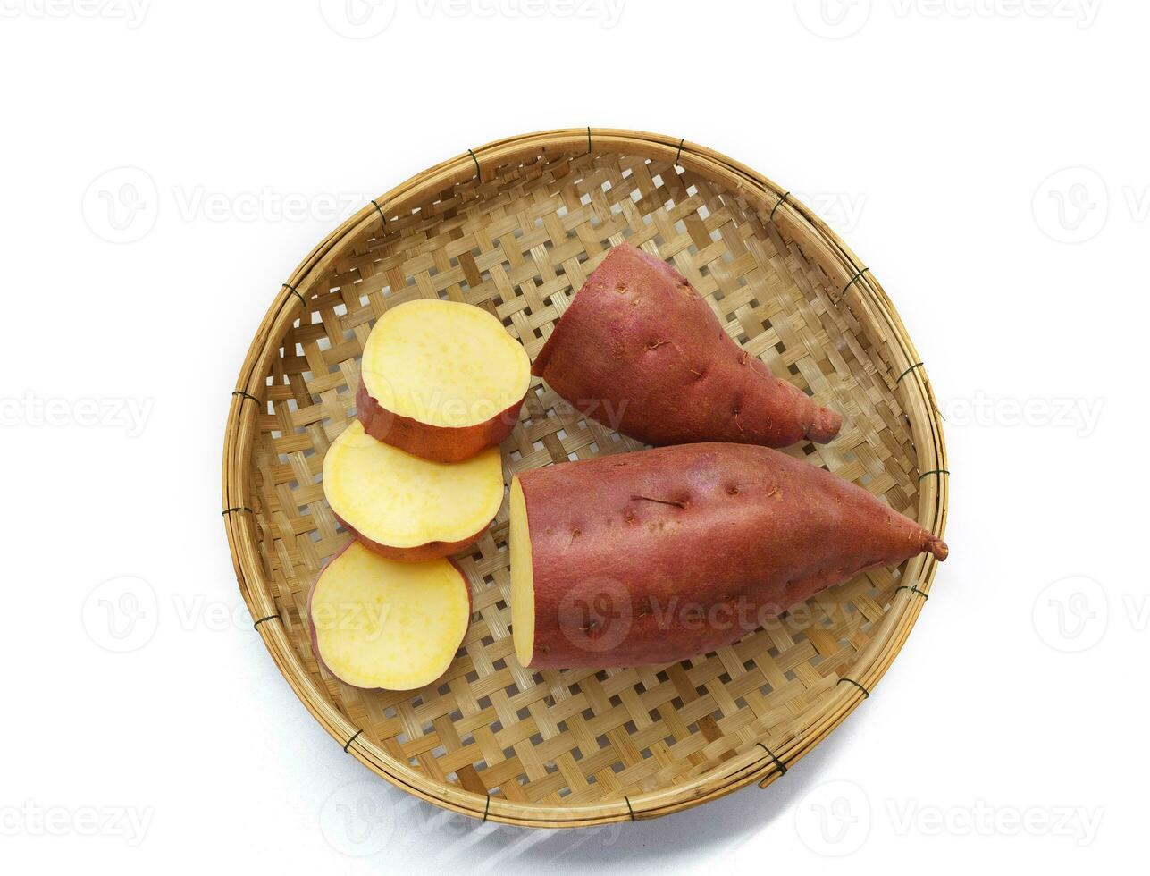 Sweet potato in woven wooden tray isolated on white background. Top view. photo