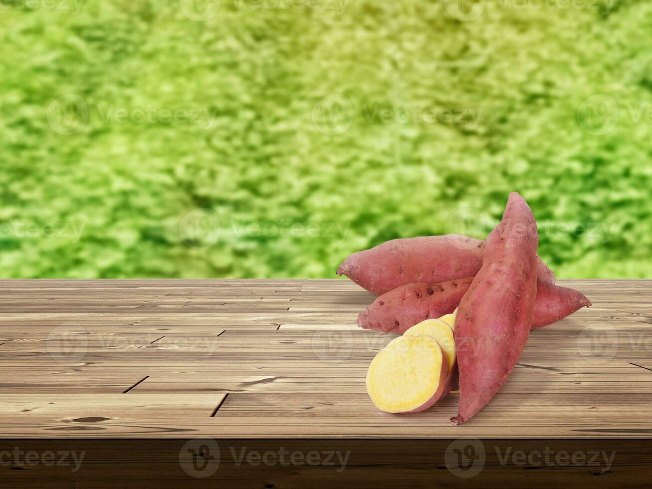 sweet potato on wooden table There is a garden field in the background. photo