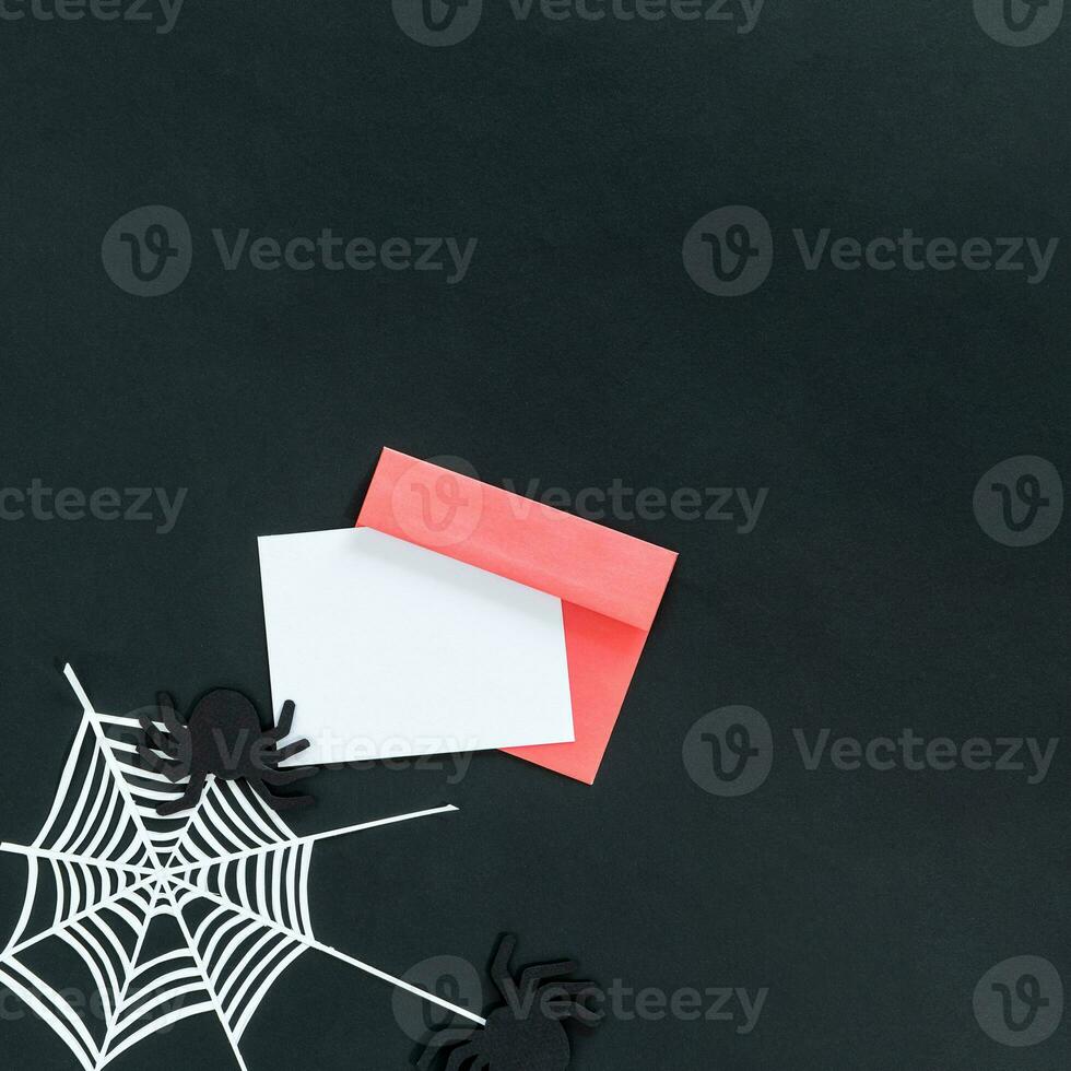 Halloween background with spider and spider web, pink envelope and card, on black background. photo
