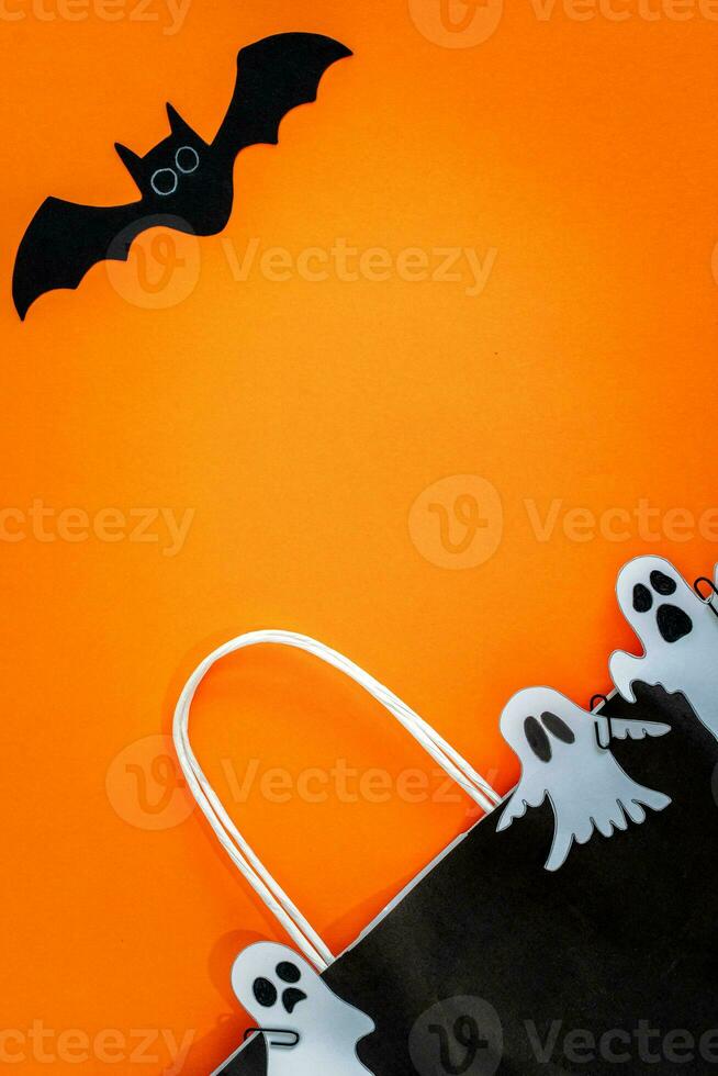 Halloween sale banner with bat, ghost and bag on orange background. photo