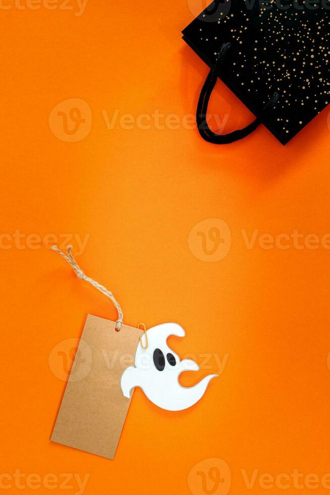 Halloween sale banner with label, ghost and bag on orange background. photo