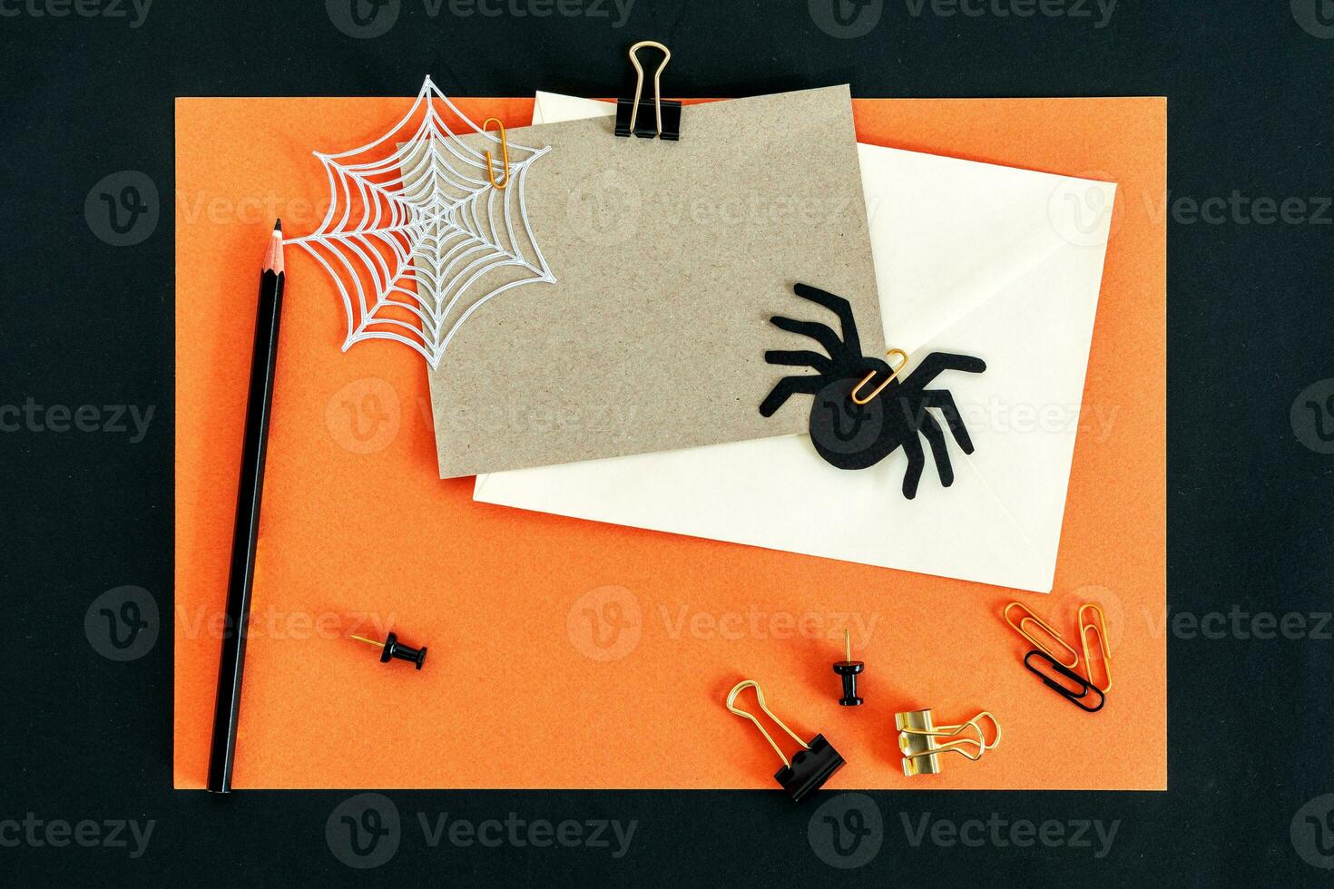 otoño otoño Víspera de Todos los Santos tema escritorio espacio de trabajo con tarjeta, sobre, lápiz, clips en elegante naranja texturizado antecedentes. foto