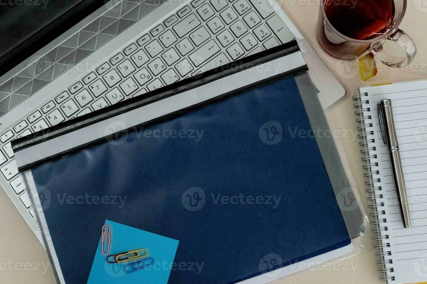 Top view office table desk with laptop, folder, tea cup, pencil, supplies. photo