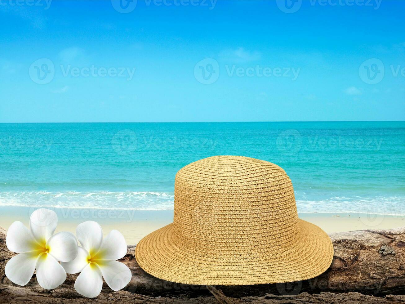 Vintage hat, wooden icon, flowers and tropical sea background. summer paradise cruise travel design tourism, beach, holiday travel destination concept photo