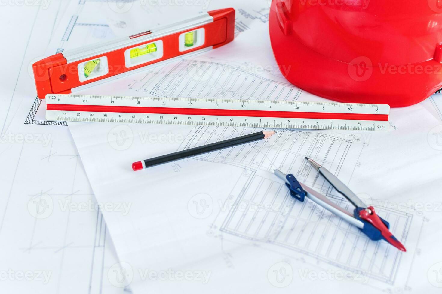 Construction plans with red helmet and drawing tools on blueprints. photo