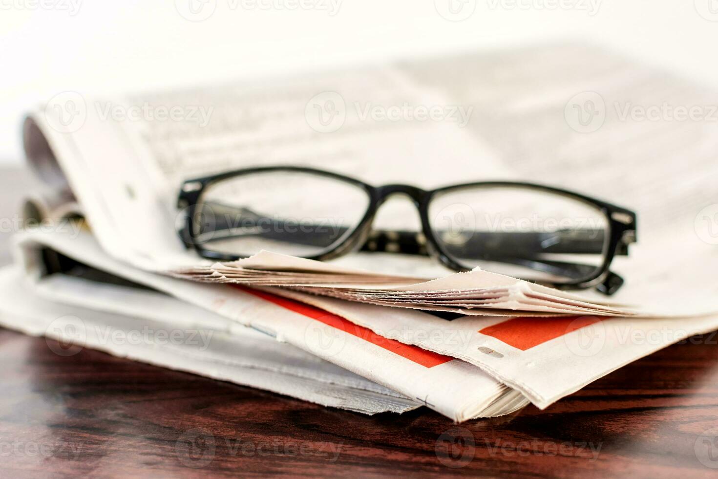 Newspaper and reading glasses on wooden table. photo