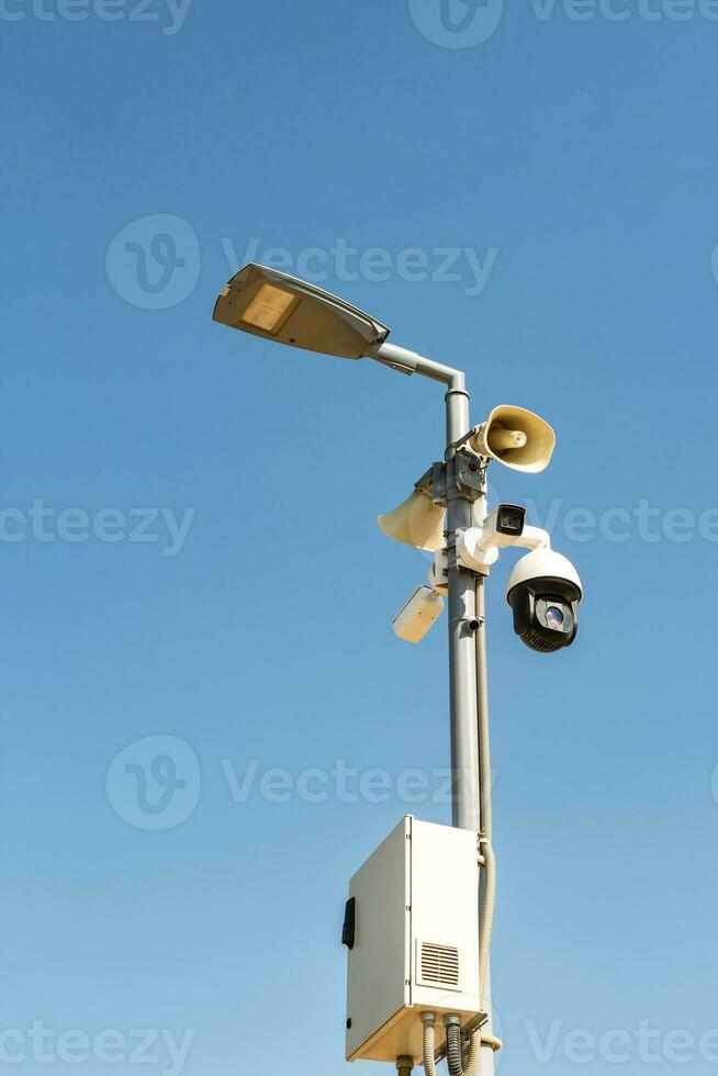 Cluster of security cameras on a lamppost, in an public Park on the sky background, with copy space. photo