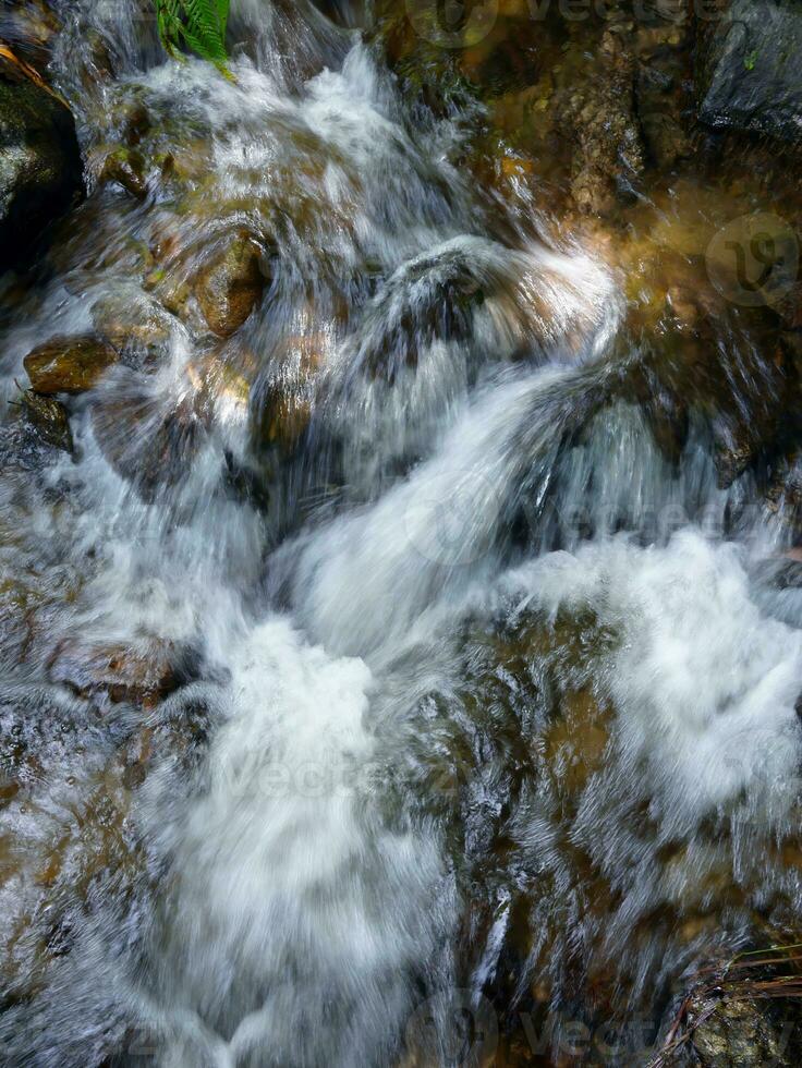 Slow motion natural cascade waterfall, tropical rainforest waterscape, long exposure shot, slope of rocks, beautiful nature for background wallpaper photo