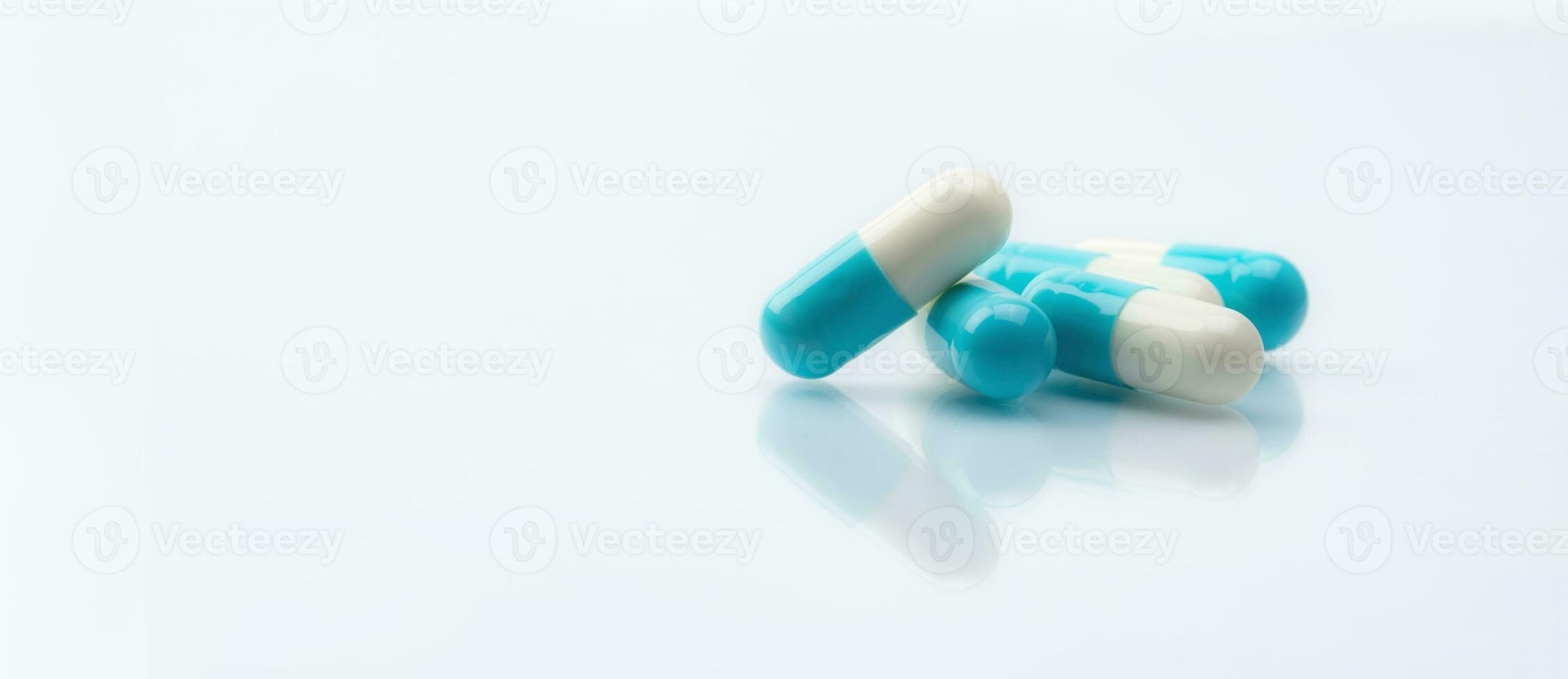 Blue-white capsule pills on white background. Pharmacy banner. Prescription drug. Healthcare and medicine. Pharmaceutical industry. Pharmaceutical science. Drug safety. Prescription medication. photo