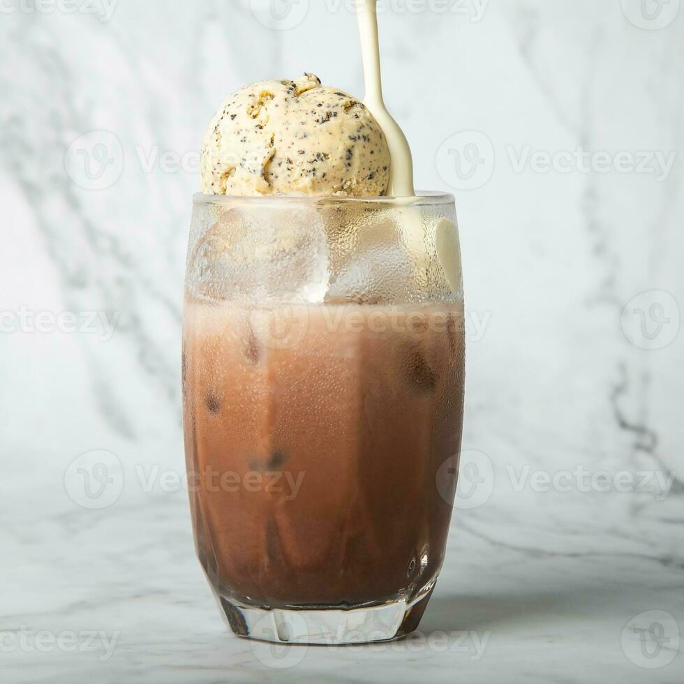 Pour the almond milk cream. Iced cocoa with vanilla ice cream in clear glass on marble Copy space for your text. square image photo
