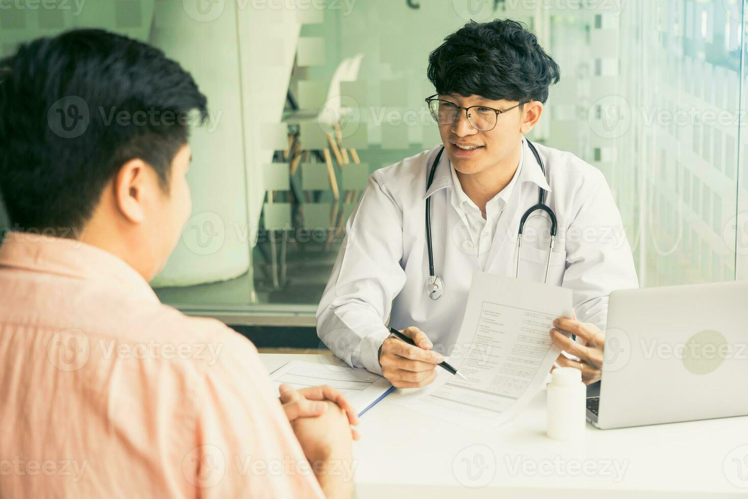 Doctor talking patient history list on note pad and talking to the patient about medication and treatment. photo