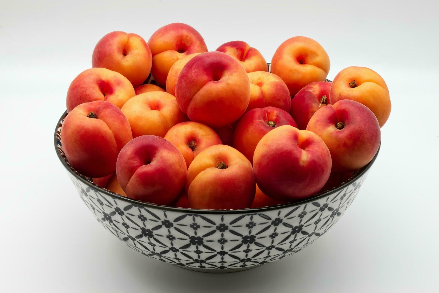Fresh apricot in a bowl isolated on white background photo