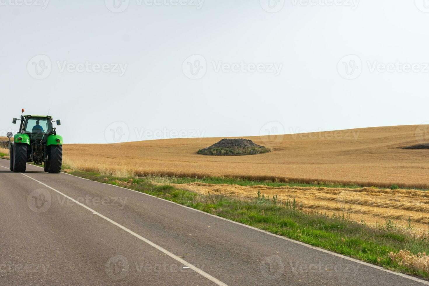 tractor on the road in the middle of sown fields photo