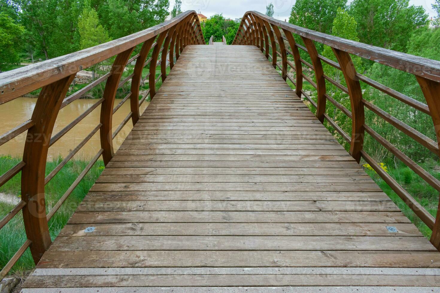 modern wooden bridge under cloudy skies photo