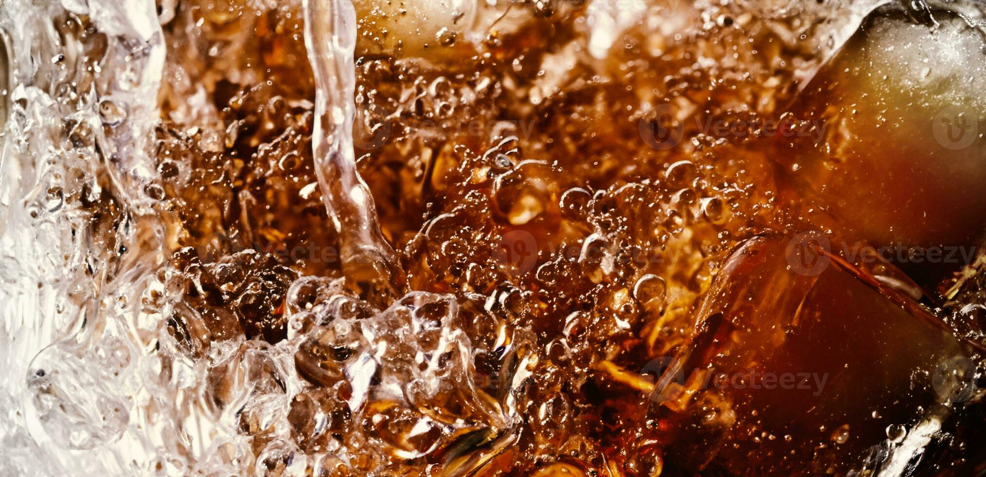 Splashing of Cola and Ice. Cola soda and ice splashing fizzing or floating up to top of surface. Close up of ice in cola water. Texture of carbonate drink with bubbles in glass. Cold drink background photo