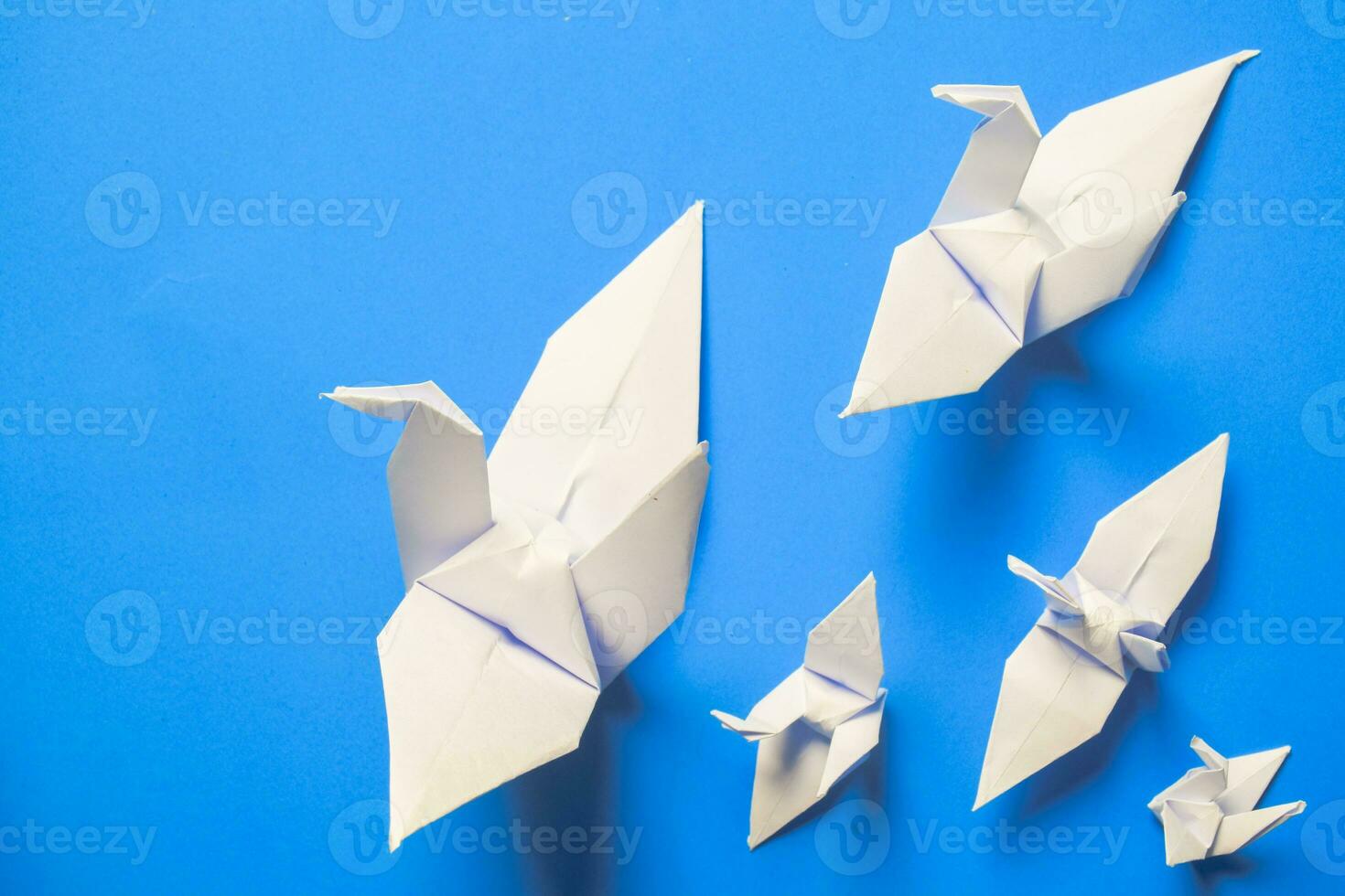 blanco pájaro origami papel en azul antecedentes. pájaro paz, libertad o oportunidades concepto foto