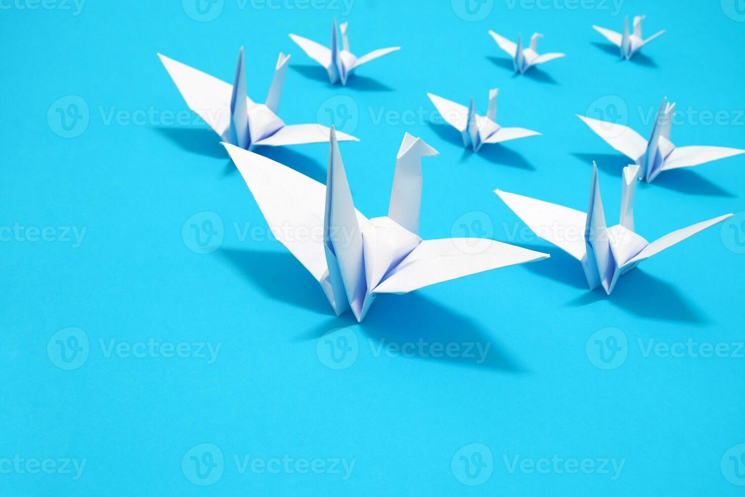 blanco pájaro origami papel en azul antecedentes. pájaro paz, libertad o oportunidades concepto foto
