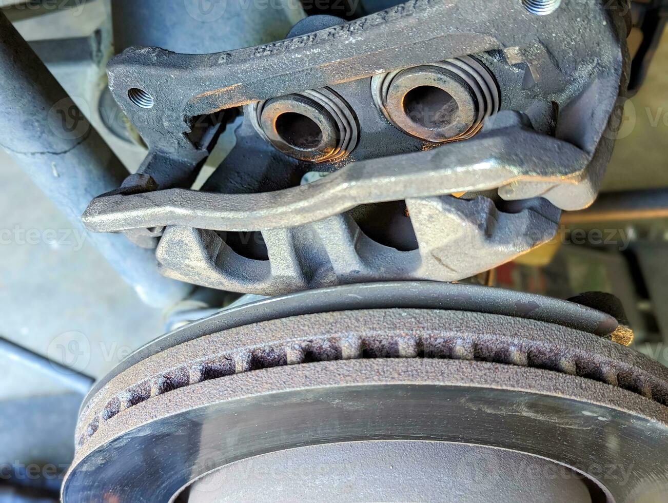 Brake Disc of the vehicle for repair.Automobile mechanic in process of new break replacement.Car brake repairing in garage.Car Service and technician concept. photo