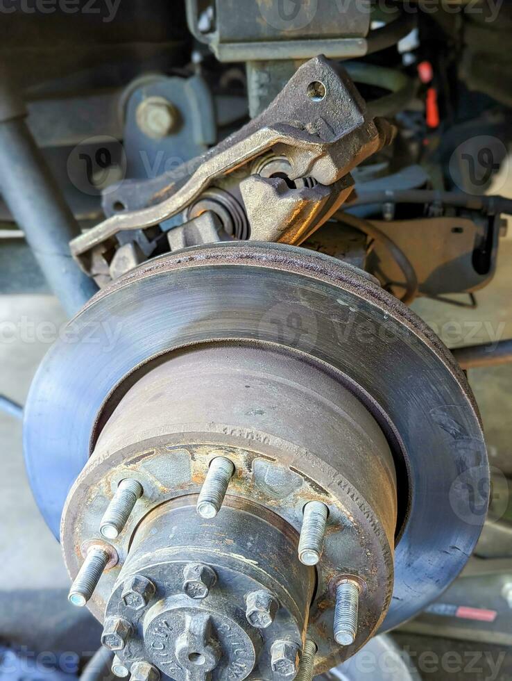 Brake Disc of the vehicle for repair.Automobile mechanic in process of new break replacement.Car brake repairing in garage.Car Service and technician concept. photo