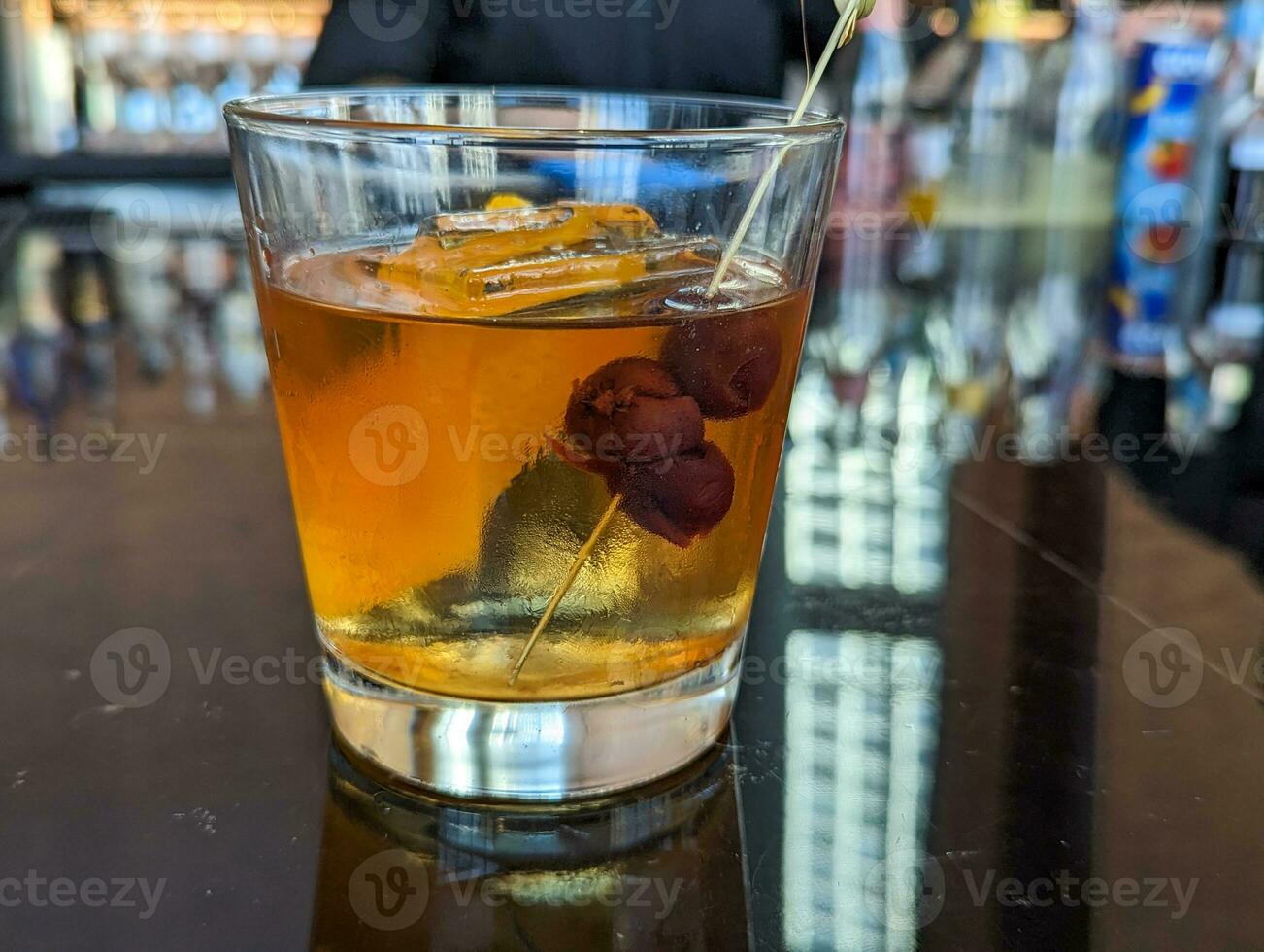 shot of whisky based cocktails with ice cubes on the bar. Fine alcohol, bold fashion drink. photo