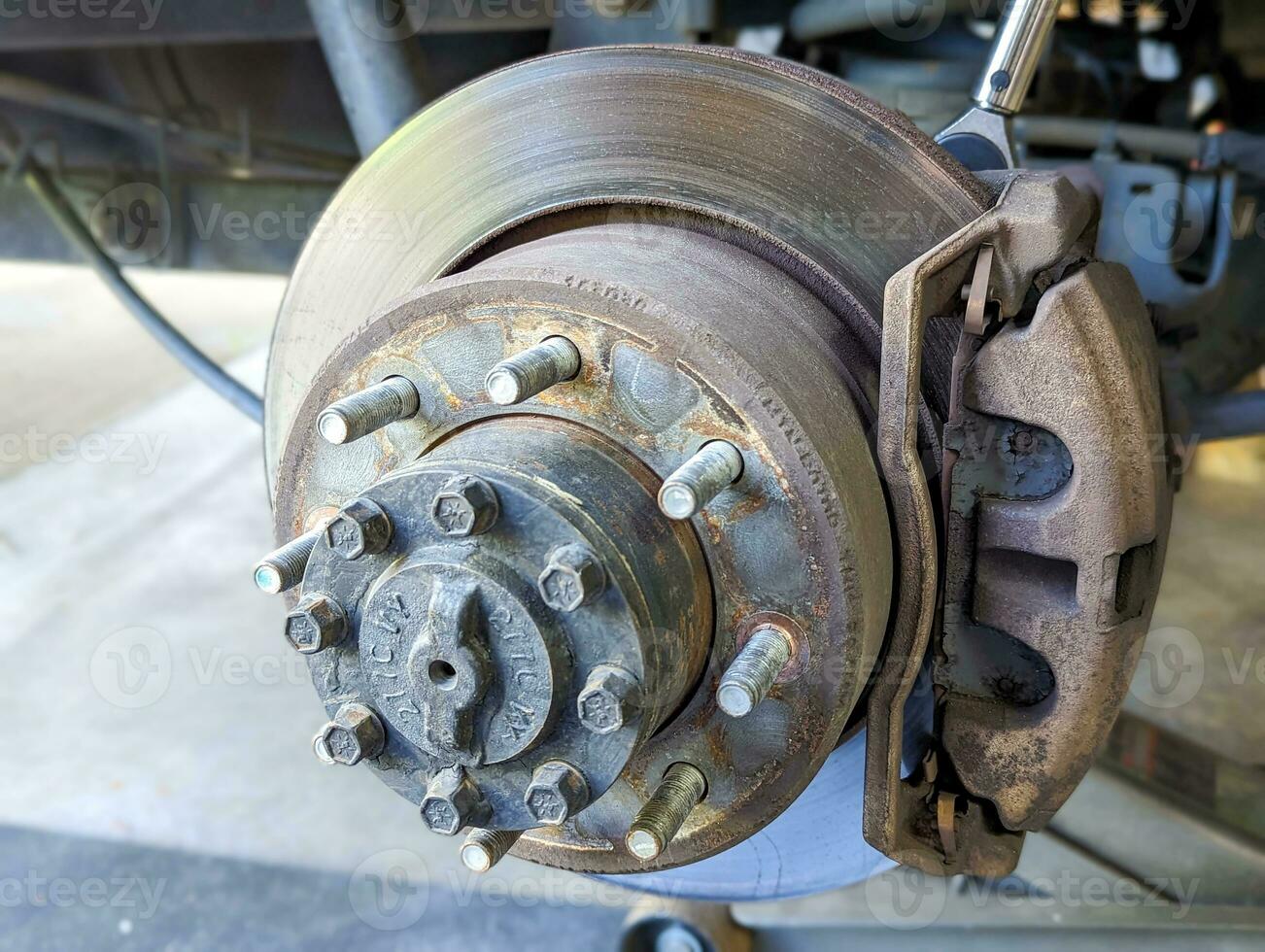 Brake Disc of the vehicle for repair.Automobile mechanic in process of new break replacement.Car brake repairing in garage.Car Service and technician concept. photo