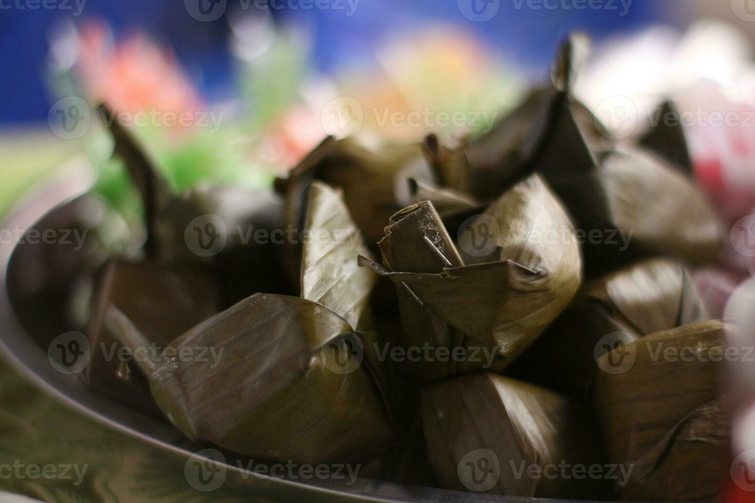 lemper, a traditional snack from Indonesia made of glutinous rice with shredded beef filling, selective focus at the place of celebration. photo