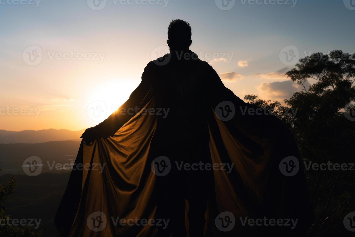 a man in a raincoat stands on a mountain at sunset close-up rear view photo