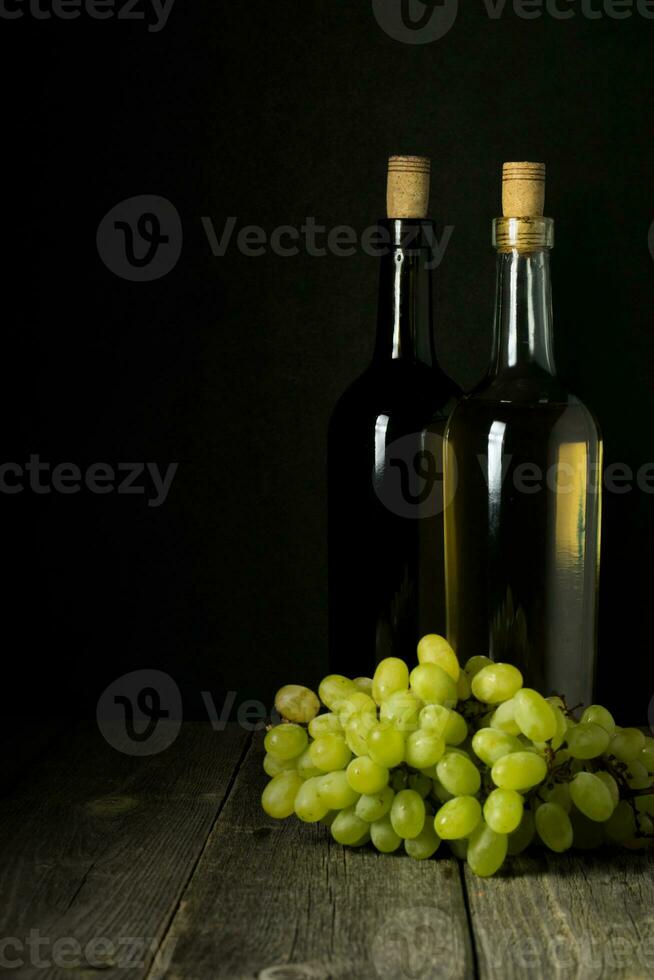 Glass bottle of wine with corks on wooden table background photo