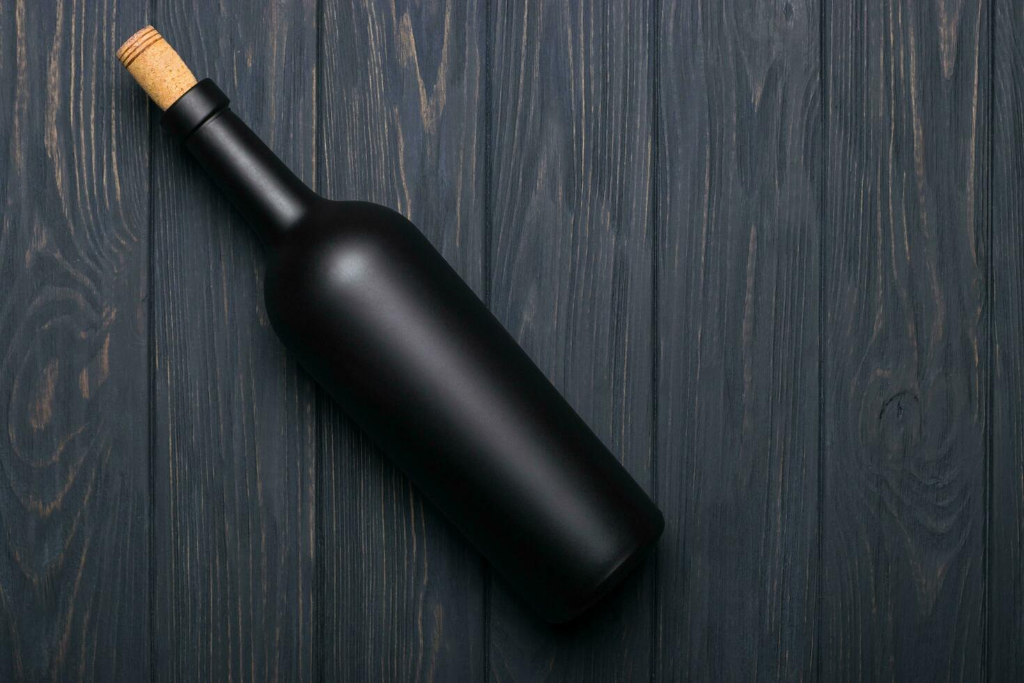 Wine bottle on dark wooden background. Mock-up photo