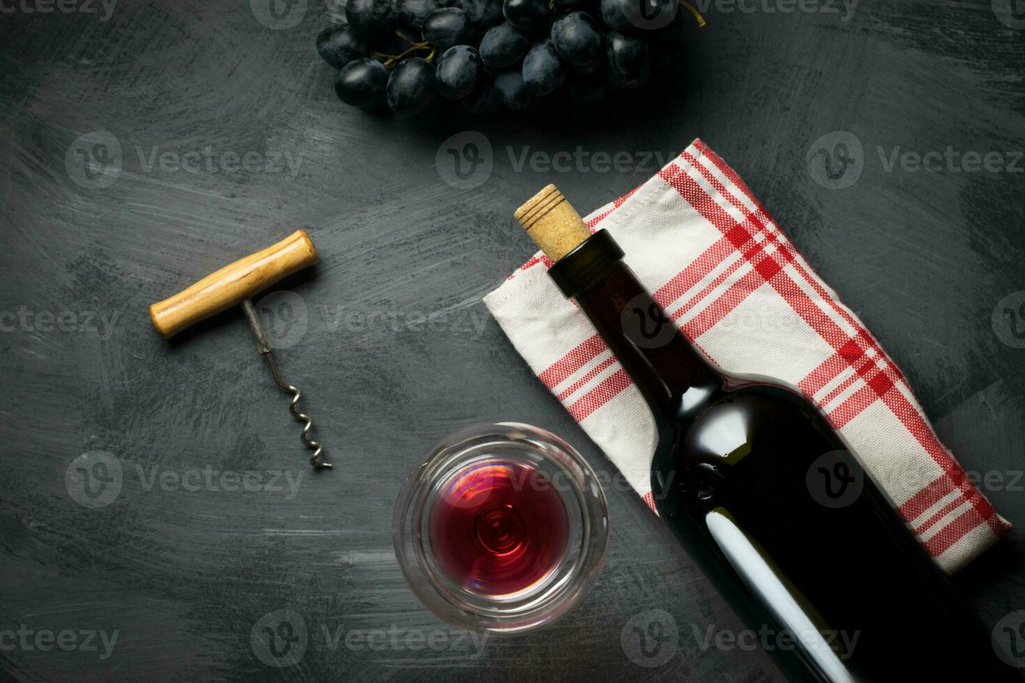 Glass bottle of wine with corks on wooden table background photo